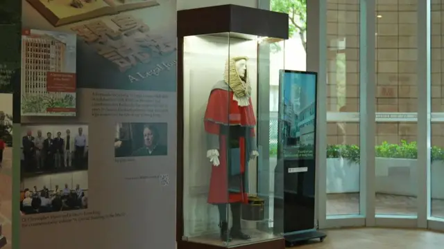 展示櫃內陳列著一套英國法官傳統服飾，旁邊的展板介紹法律歷史與相關活動。