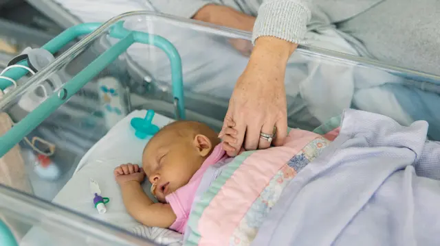 младенец с женской рукой