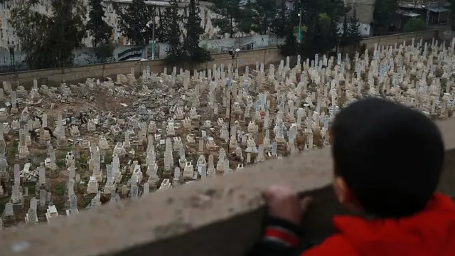 Suriye'de mezarlığa bakan çocuk