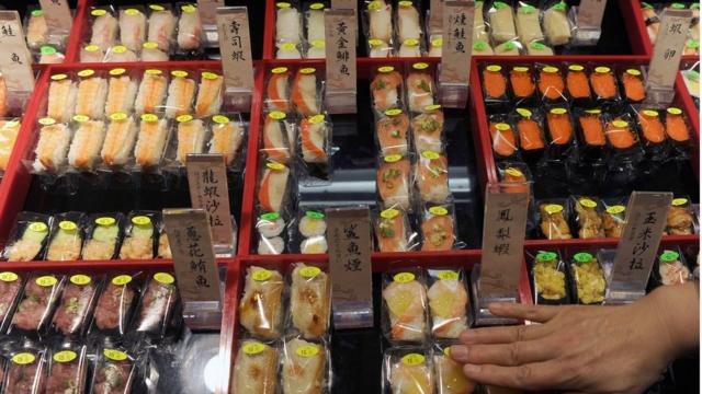 A supermarket worker places sushi in a shop in Hsintien, New Taipei City, on March 16, 2011. Asian diners are still tucking into sushi at restaurants around the region despite fears that elevated radiation levels in Japan could reach the food chain and contaminate raw ingredients.