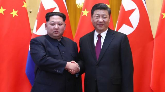 金正恩（左）与习近平（右）握手（新华社2018年3月28日发布图片）