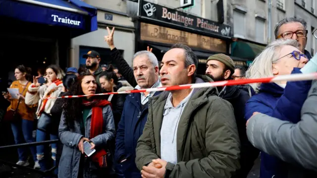 La gente se reúne cerca de la Rue d'Enghien después del tiroteo donde murieron al menos 3 personas en un distrito central de París, Francia.