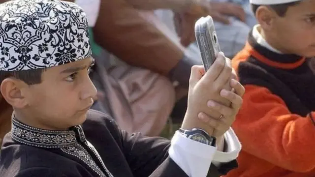 मोबाइल देखता एक बच्चा