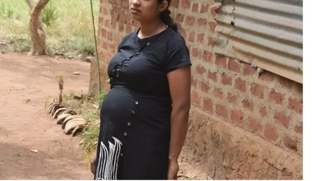 Thakshila Niroshini, a 27-year-old pregnant mother from Vavuniya in northern Sri Lanka stands outside a building
