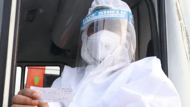 श्मशान पर टोकन की पर्ची दिखाता एक व्यक्ति