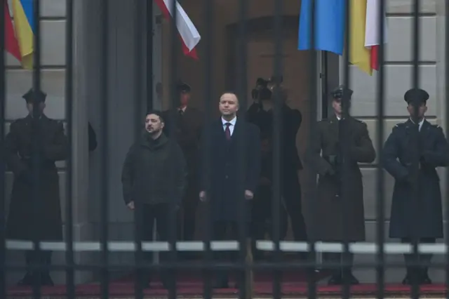 Зеленский и Навроцкий стоят на ступеньках перед входом в президентский дворец. По обе стороны стоят военные в форме.