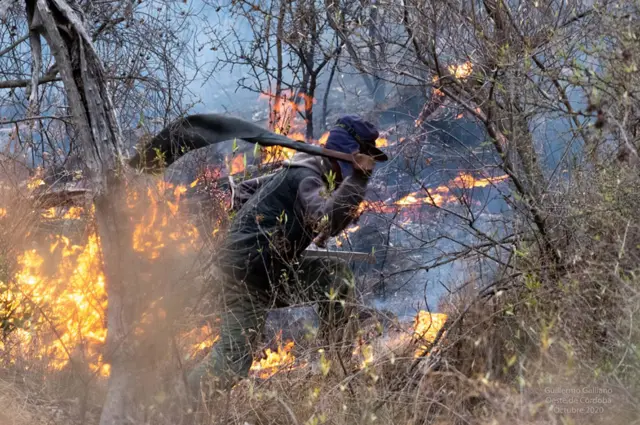 Un hombre apagando fuegos con un chicote