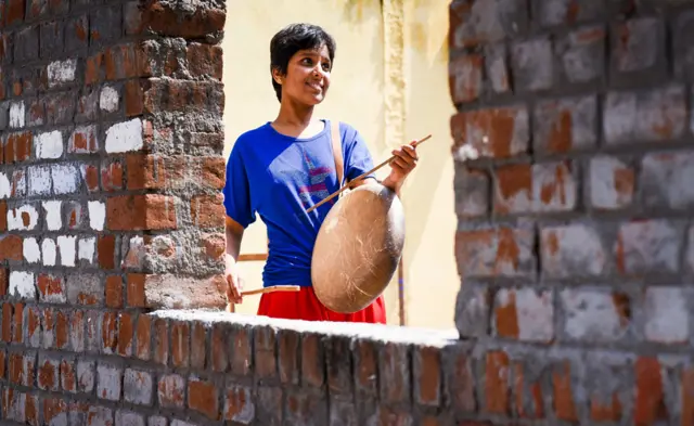 Kausália tocando tambor típico dos Dalits