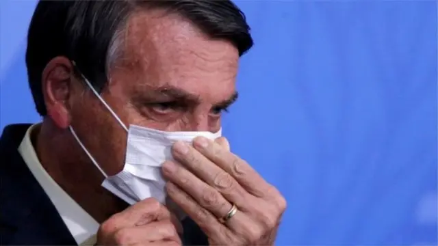 Bolsonaro usa máscara e mexe no rosto