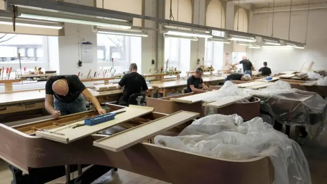Trabajadores en una fábrica de pianos.