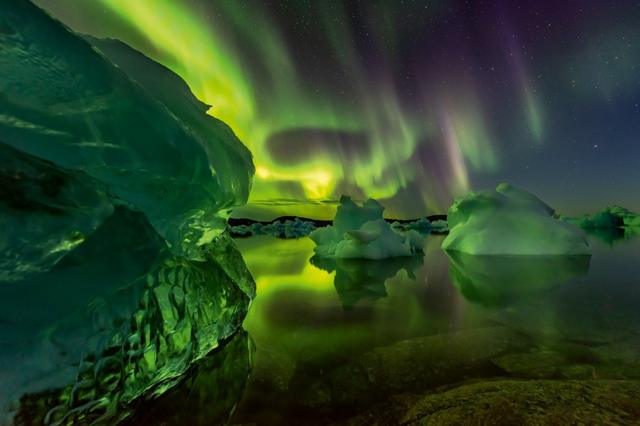 The northern lights seen above icebergs
