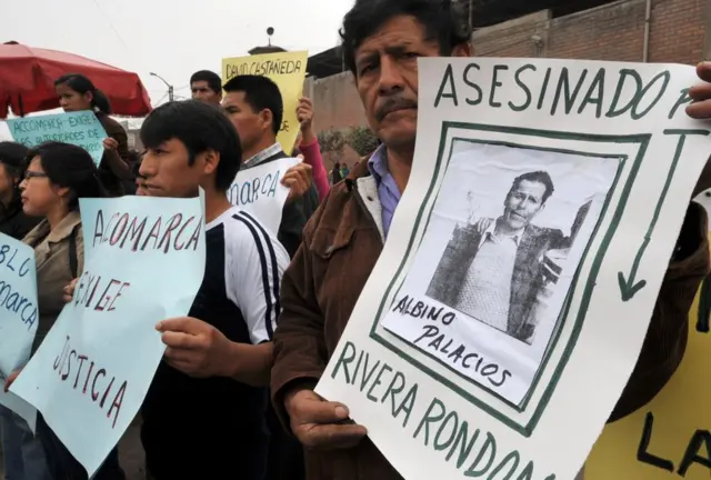 Familiares de víctimas sujetan carteles y exigen justicia por el caso Accomarca en 2010.