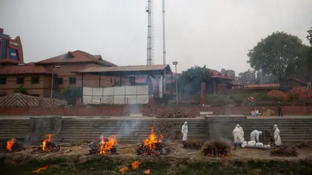 काठमांडू में बागमती नदी के किनारे जलते कोविड पीड़ितों के शव