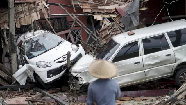 An Indonesian man looks at ruined vehicles after a tsunami hit Sunda Strait in Anyer, Banten, Indonesia, 23 December 2018.