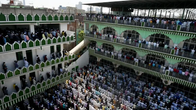 یک مسجد دو طبقه که مسلمانان در حال نماز خواندن هستند