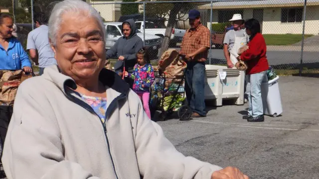 Personas esperando a recibir comida de un banco de alimentos