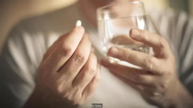 Seseorang hendak minum obat.