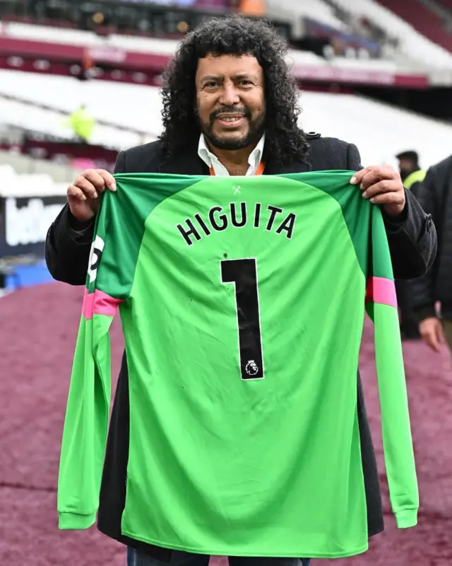 Higuita posa con una camiseta con su nombre.