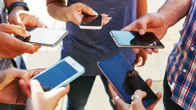 Diferentes manos sostienen teléfonos móviles