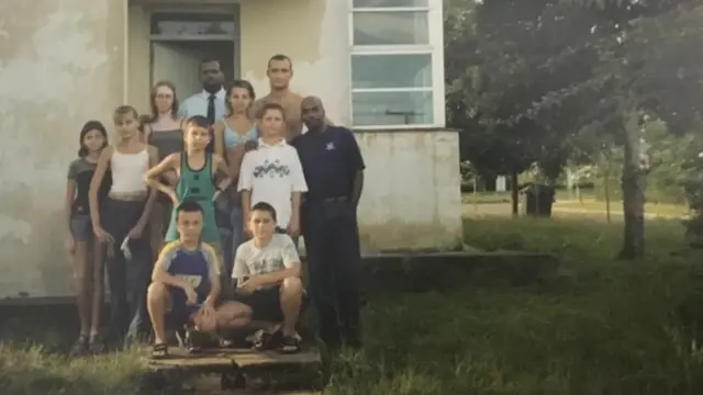 Grupo de niños y adultos frente a un edificio en el complejo de Tarará, Cuba