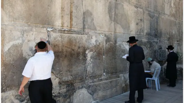 'টম্ব অব দ্য প্যাট্রিয়ার্ক' এর বাইরে প্রার্থনা করছেন কয়েকজন গোঁড়া ইহুদী।
