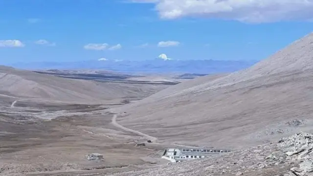 منطقه مرزی در هوملا، نپال، با ساختمانهای چینی در پیشزمینه و کوه پوشیده از برف کایلاش در دوردست