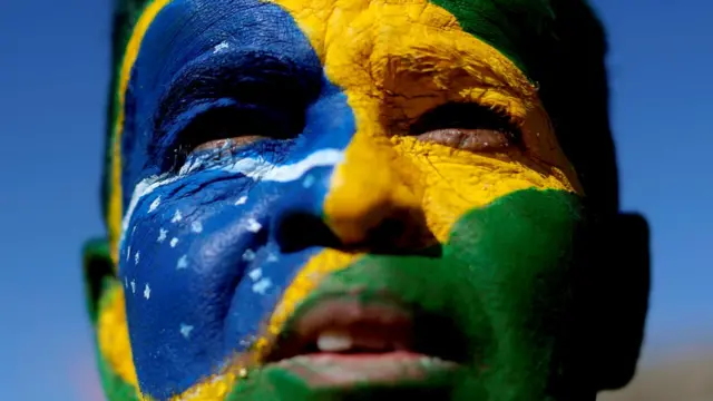 Homem com rosto pintado com a bandeira do Brasil durante manifestação a favor da operação Lava-Jato e do ministro Sergio Moropremier league apostasjunho