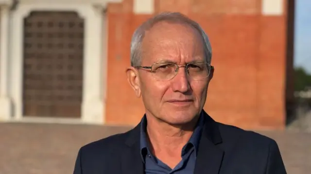 Franco Bolzonaro en frente de la iglesia de su ciudad.