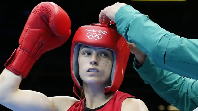 Una mujer boxeadora con el protector en su cabeza.