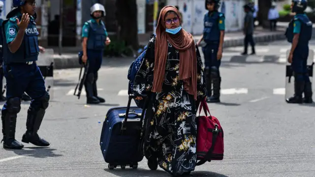 ढाका में कॉलेज होस्टल छोड़कर जा री एक छात्रा