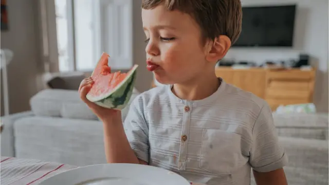 garoto comendo melancia