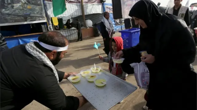 ينتشر على امتداد الطرق متطوعون يقدمون الطعام والشراب مجانا للزوار القادمين سيرا على الأقدام الى المرقد