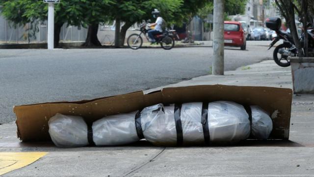 Cadáver envuelto en plástico en medio sobre una acera de Guayaquil.