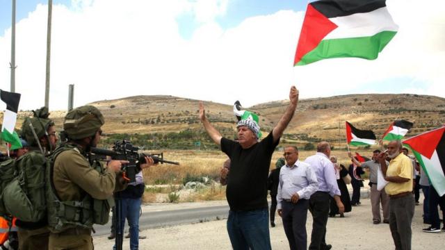 Un manifestante palestino de Cisjordania protesta frente a soldados israelíes.