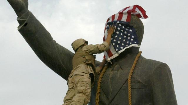 Un Marine américain recouvre le visage de la statue de Saddam Hussein à Bagdad.