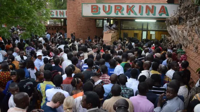 Des gens attendent devant une salle de cinéma pendant le 24e Festival panafricain du cinéma de Ouagadougou (FESPACO), le plus grand festival de cinéma en Afrique, le 5 mars 2015