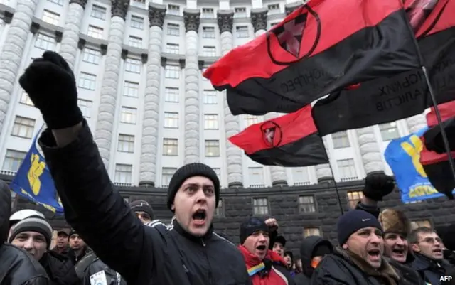 Protesters wave Ukrainian Insurgent Army flag