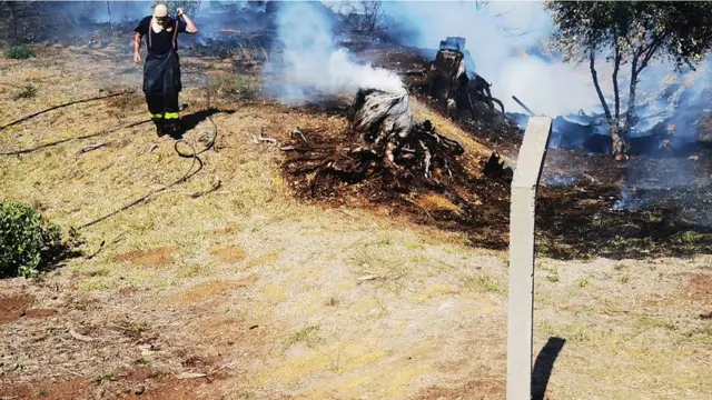 Fire fighters dey try quench di fire fir di Table Mountain