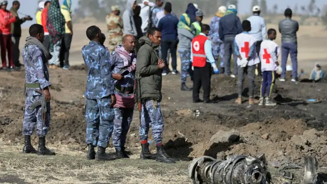 أشخاص يقفون إلى جانب حطام طائرة