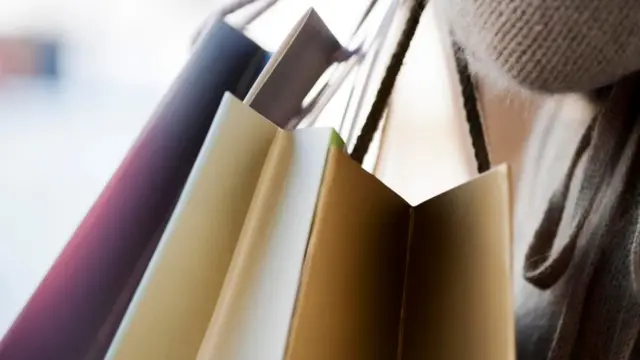 سيدة تحمل عدة حقائب للتسوق