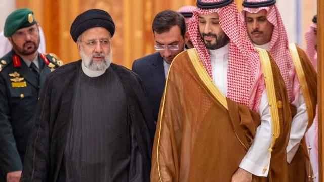 サミット会場で並んで歩くイランのライシ大統領（前左）とサウジアラビアのムハンマド・ビン・サルマン皇太子（前右、11日）
