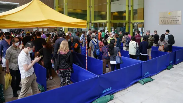 香港市民在西区中山纪念公园体育馆社区疫苗接种中心门前排起长龙准备接种复必泰疫苗（中新社图片5/4/2021）