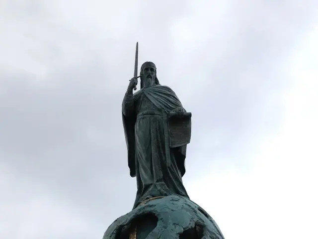 Na spomeniku Stefan Nemanja u desnoj ruci drži mač, a u levoj Hilandarsku povelju