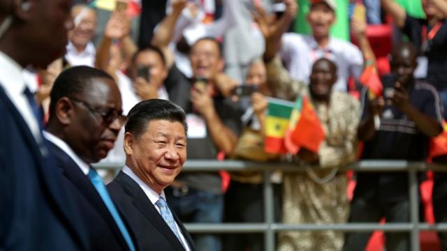 Senegal"s President Macky Sall and Chinese President Xi Jinping enter the stadium during the opening ceremony of the Arene Nationale du Senegal in Dakar
