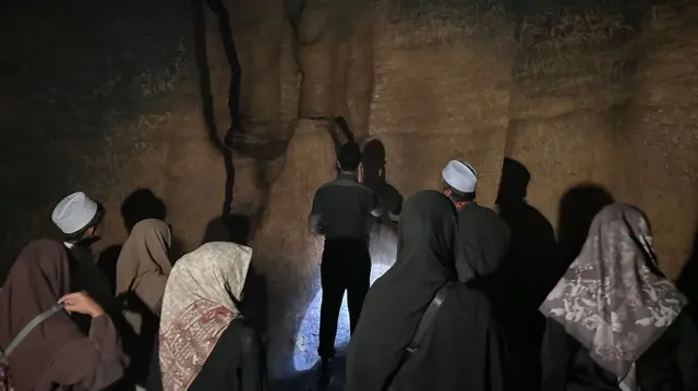 Seorang pengunjung mengumandangkan azan di sebuah bilik paling besar dalam gua, yang disebut masjid agung.