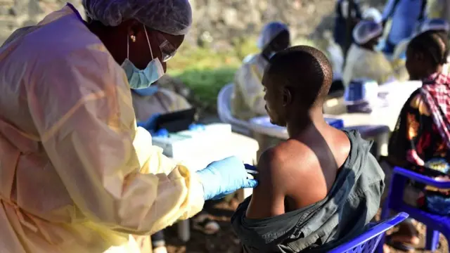 Un travailleur de la santé congolais vaccine un homme contre le virus Ebola au centre de santé Himbi à Goma, en République démocratique du Congo, le 17 juillet 2019