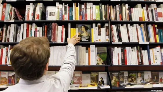 પુસ્તકો વચ્ચે એક વ્યક્તિ