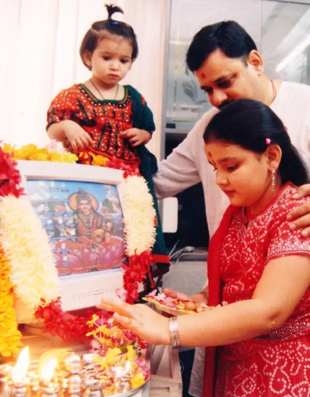 દિવાળીના તહેવાર પર કમ્પ્યૂટરનું પૂજન કરતી બાળકી પિતા સાથે