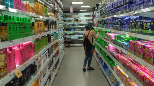 امرأة في محل - قسم فوط صحية