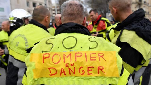 A firefighter with a vest reading "SOS firefighters in danger" takes part in a demonstration to protest against the pension overhauls, in Marseille, southern France, on 5 December, 2019